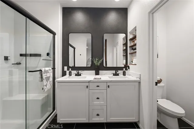 a bathroom with a double vanity sink toilet and mirror