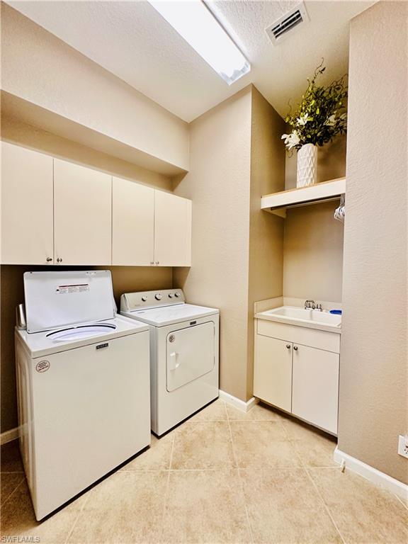16152 Parque Lane Naples, FL 34110 - Photo 13 of 49 Clothes washing area featuring light tile patterned floors, a textured ceiling, washer and dryer, cabinets, and sink