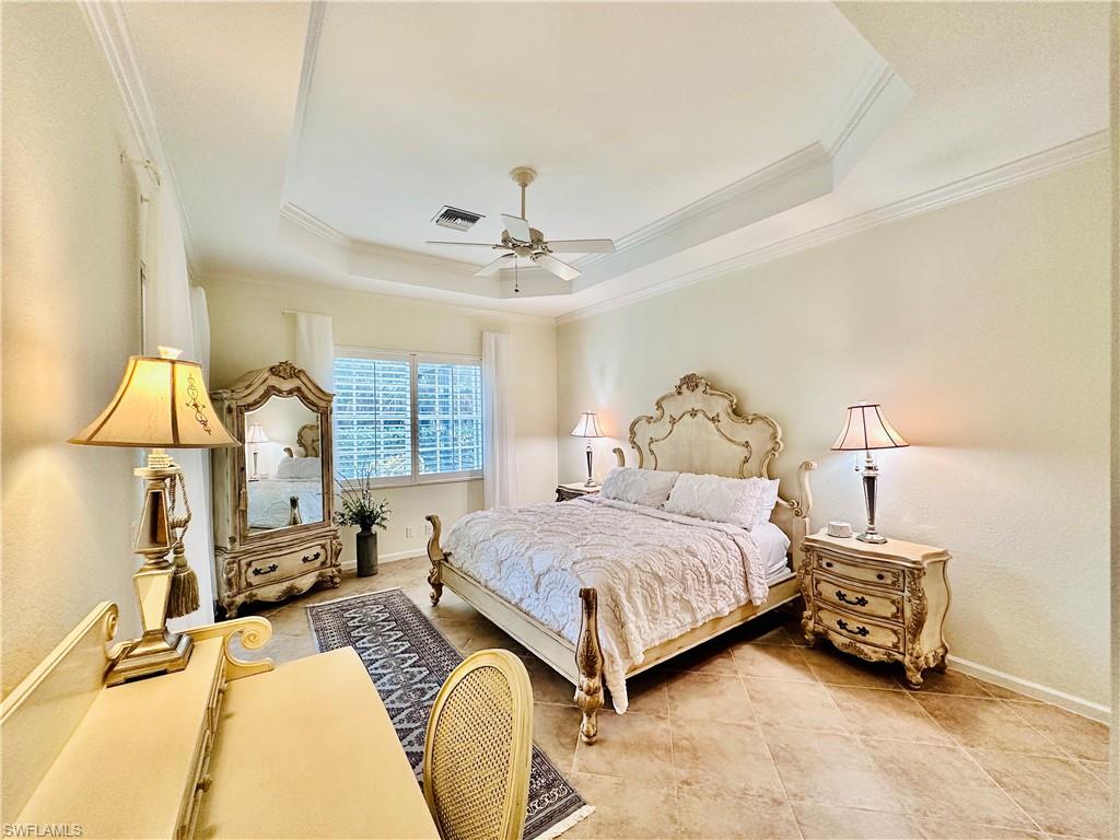16152 Parque Lane Naples, FL 34110 - Photo 14 of 49 Bedroom with ornamental molding, light tile patterned flooring, ceiling fan, and a tray ceiling