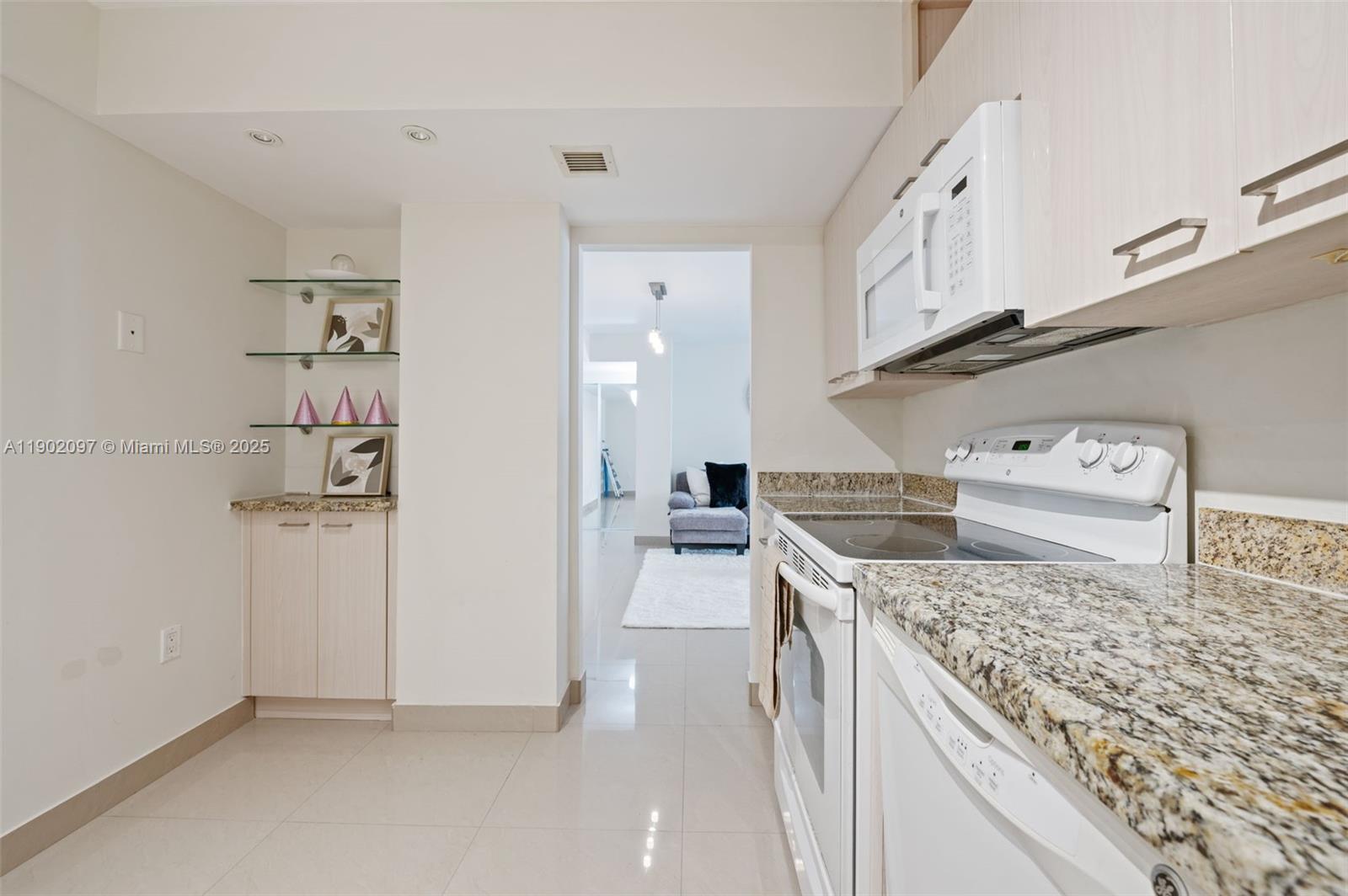 1833 South Ocean Drive, Unit 809 Hallandale Beach, FL 33009 - Photo 11 of 26 a kitchen with stainless steel appliances granite countertop a stove and cabinets