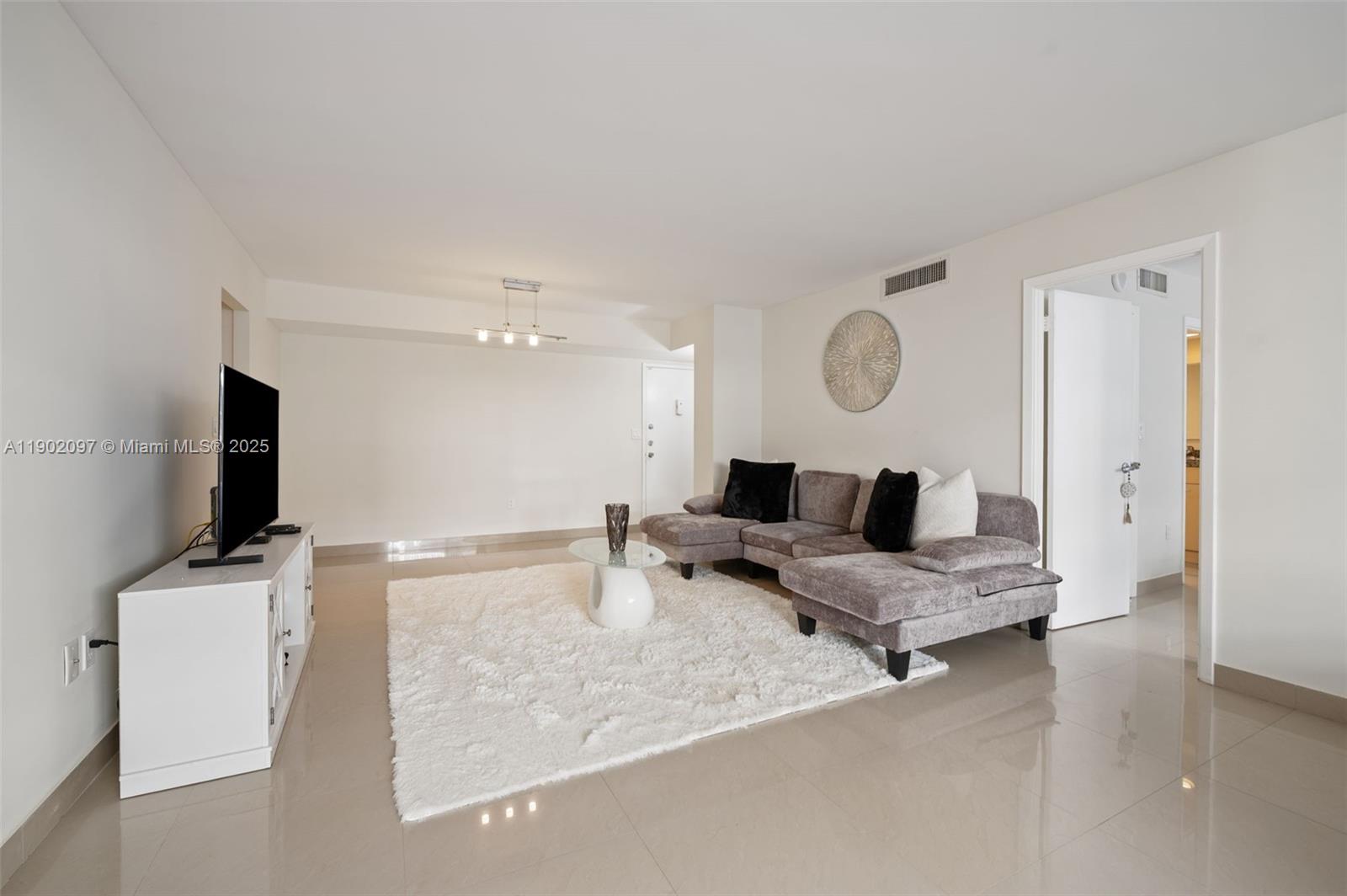 1833 South Ocean Drive, Unit 809 Hallandale Beach, FL 33009 - Photo 7 of 26 a living room with furniture and a flat screen tv