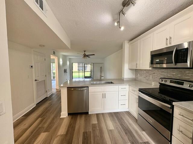 a large kitchen with a stove and white cabinets