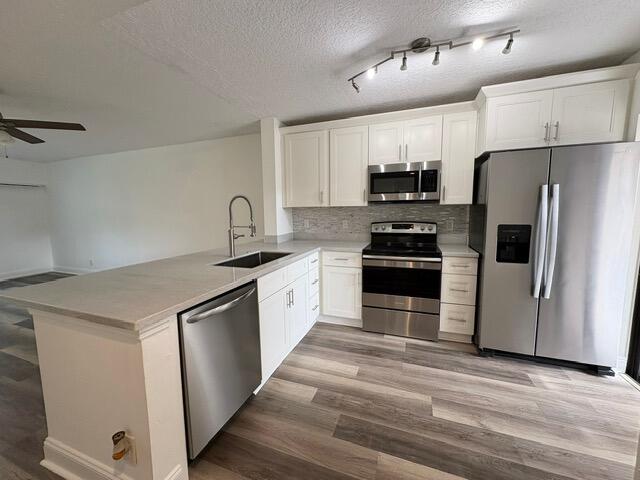 3939 Northeast 5th Avenue, Unit B102 Boca Raton, FL 33431 - Photo 4 of 20 a kitchen with granite countertop a refrigerator and a stove top oven