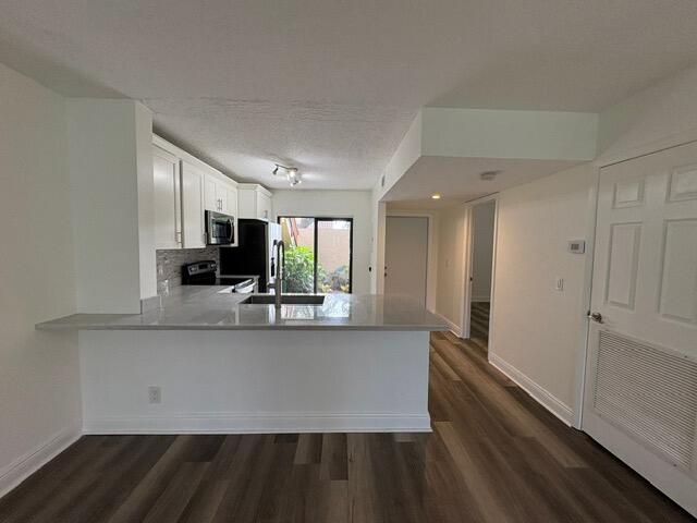 3939 Northeast 5th Avenue, Unit B102 Boca Raton, FL 33431 - Photo 5 of 20 a view of a kitchen with kitchen island wooden floor center island and stainless steel appliances