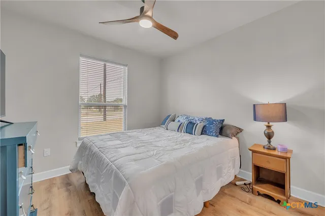 a bedroom with a bed a chandelier and a window