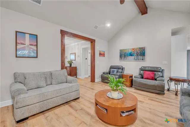 a living room with furniture and a wooden floor
