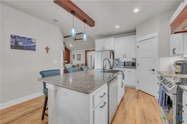 a kitchen with stainless steel appliances granite countertop a sink stove and refrigerator