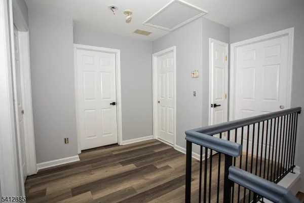 a view of a hallway with wooden floor and entryway