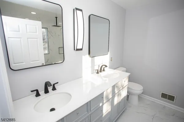 a bathroom with double vanity sink and a mirror