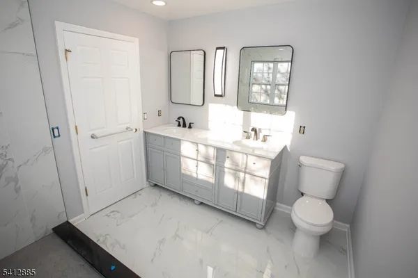 a bathroom with a toilet sink and mirror
