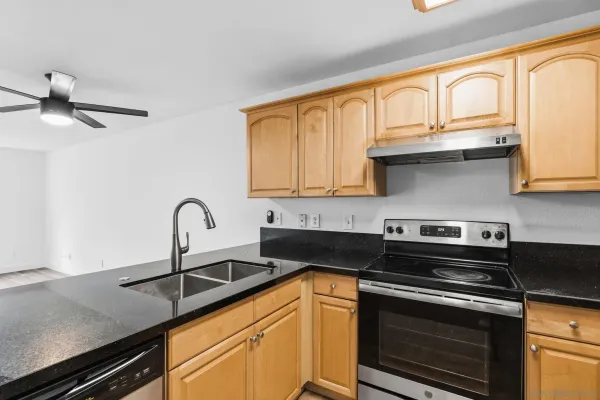 a kitchen with stainless steel appliances granite countertop a sink stove and cabinets