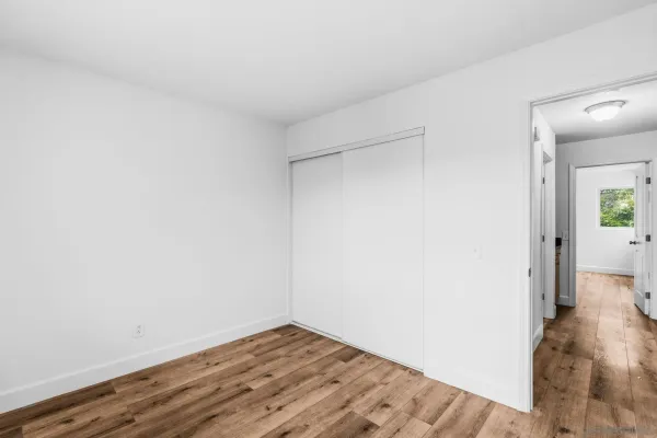 a view of a room with wooden floor
