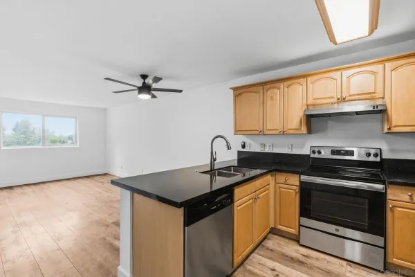 a kitchen with stainless steel appliances granite countertop a sink stove and refrigerator