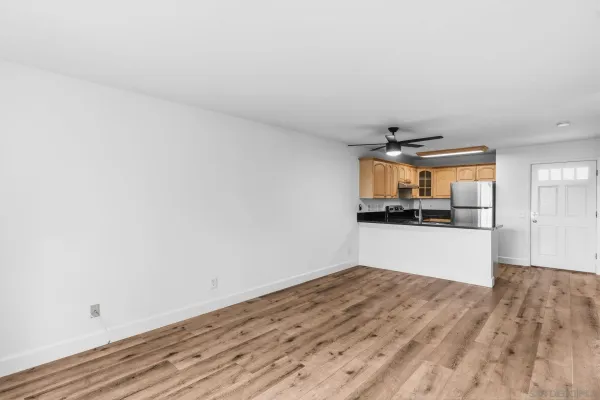 a view of a kitchen with wooden floor and a refrigerator