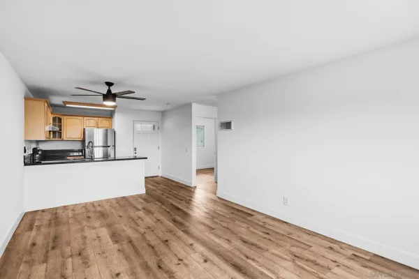 a view of a kitchen with wooden floor and a refrigerator