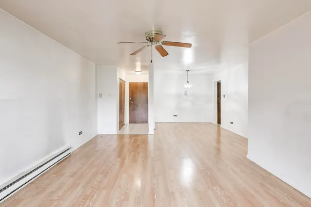 a view of empty room with wooden floor