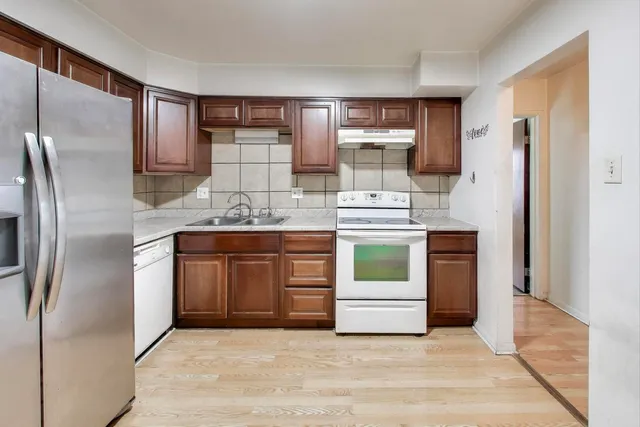 a kitchen with stainless steel appliances kitchen island granite countertop a refrigerator and a stove