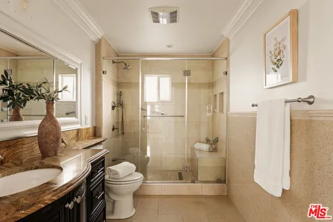 a bathroom with a granite countertop sink toilet and shower