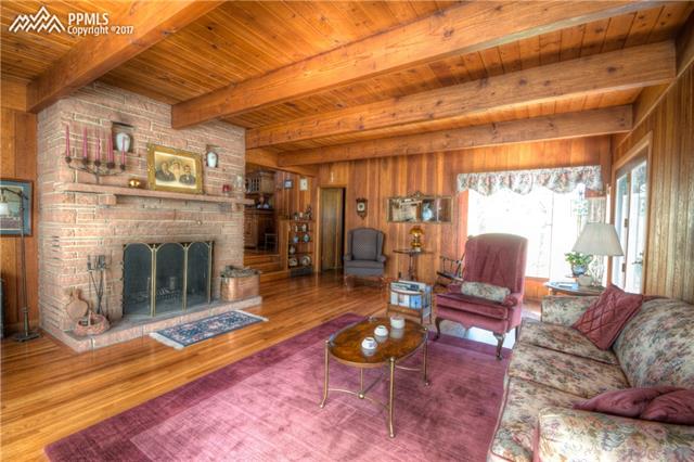 8640 Nampa Road Cascade, CO 80809 - Photo 2 of 4 Beamed ceilings and a flagstone fireplace command the entry and main living space.