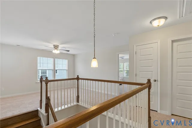 a view of staircase with railing and a chandelier
