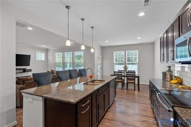 a large kitchen with kitchen island a sink table and chairs