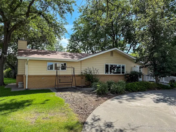 a front view of a house with a garden and plants