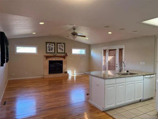 a view of a kitchen with a sink a fireplace and wooden floor