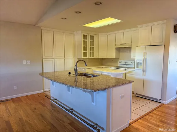 a kitchen with kitchen island granite countertop a sink and cabinets