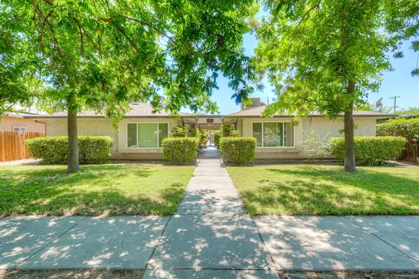 a front view of a house with a yard and trees