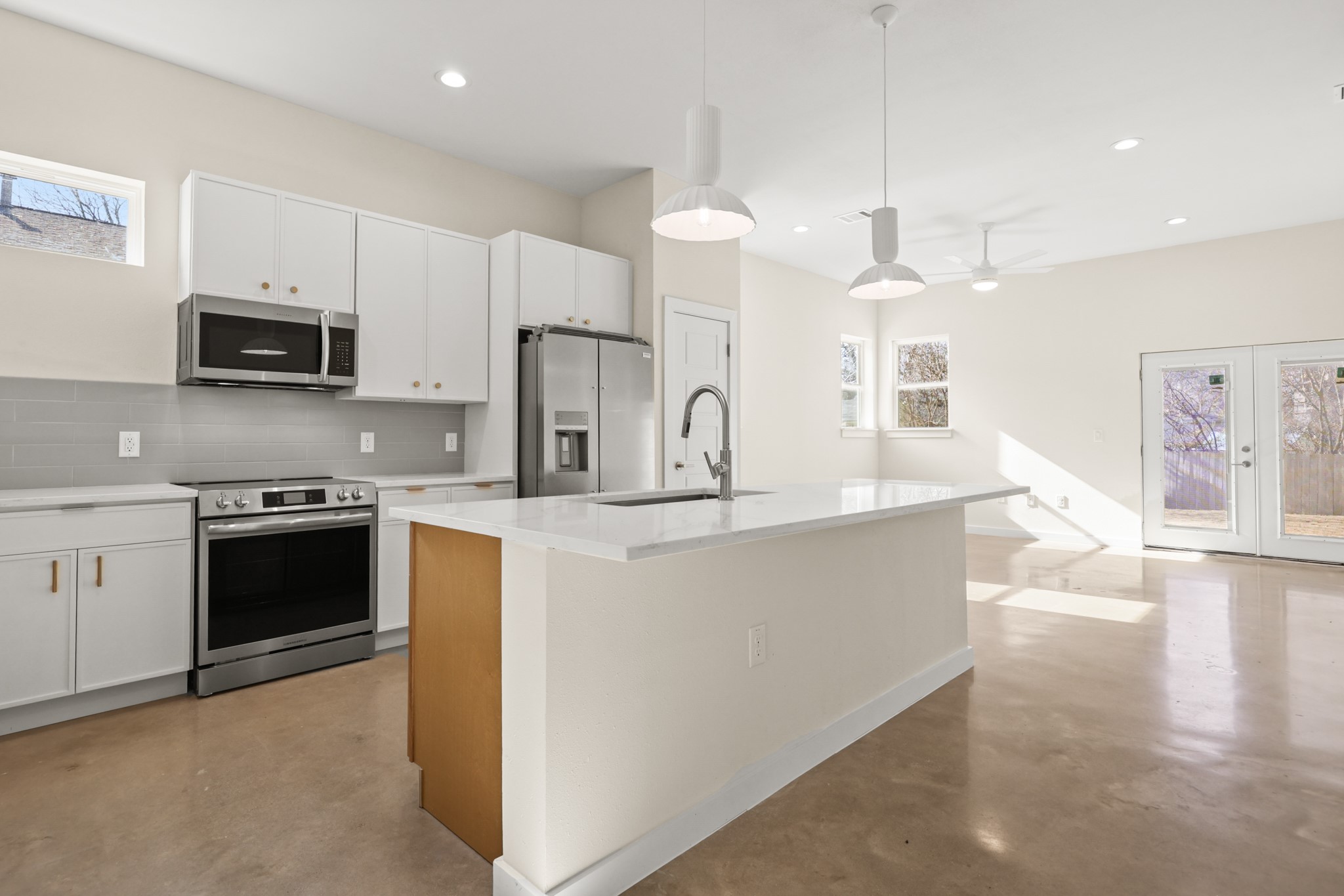4801 Sara Drive, Unit B Austin, TX 78721 - Photo 22 of 40 a large kitchen with stainless steel appliances a sink a stove a refrigerator a center island a stove and cabinets