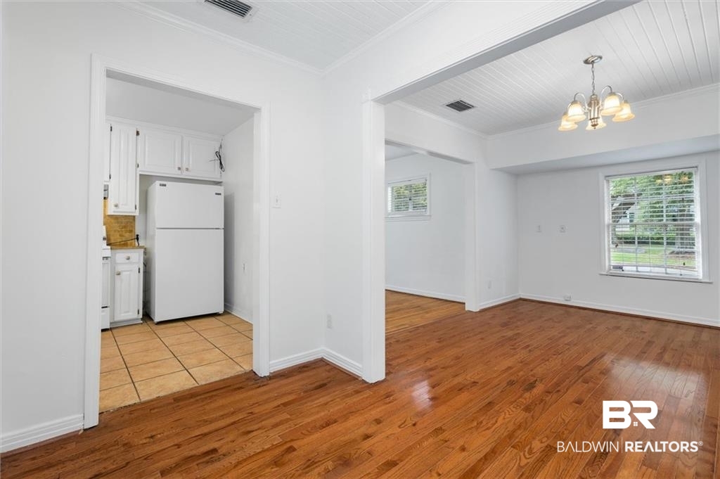 218 Grand Boulevard Mobile, AL 36607 - Photo 16 of 22 Interior space featuring white fridge, light wood-type flooring, ornamental molding, and white cabinetry