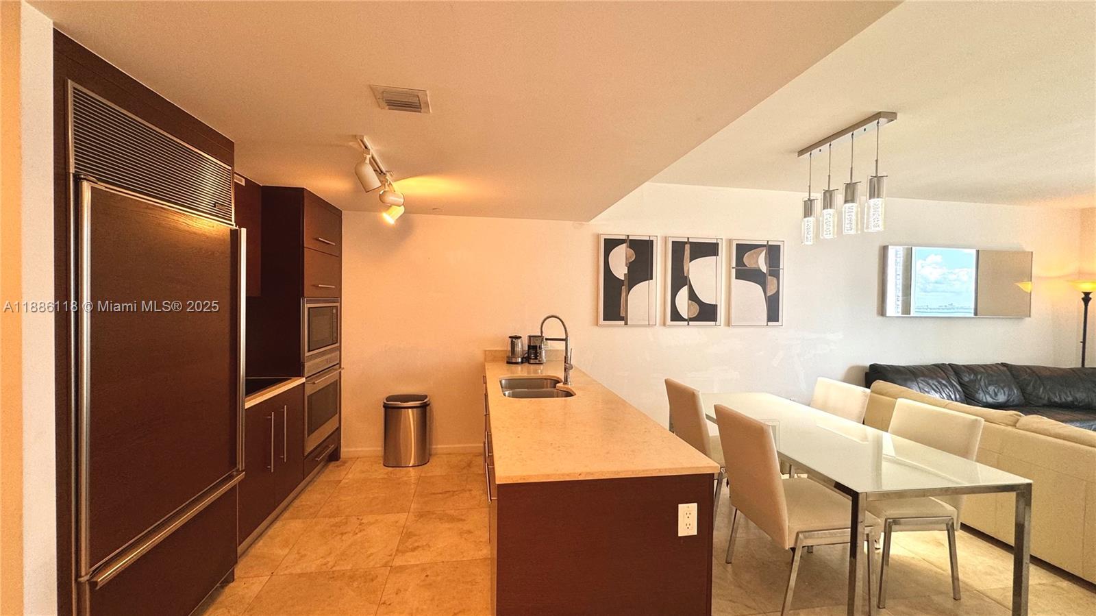 475 Brickell Avenue, Unit 2512 Miami, FL 33131 - Photo 29 of 59 a kitchen with stainless steel appliances kitchen island granite countertop a refrigerator and a stove top oven