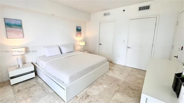 a bedroom with a bed and a lamp