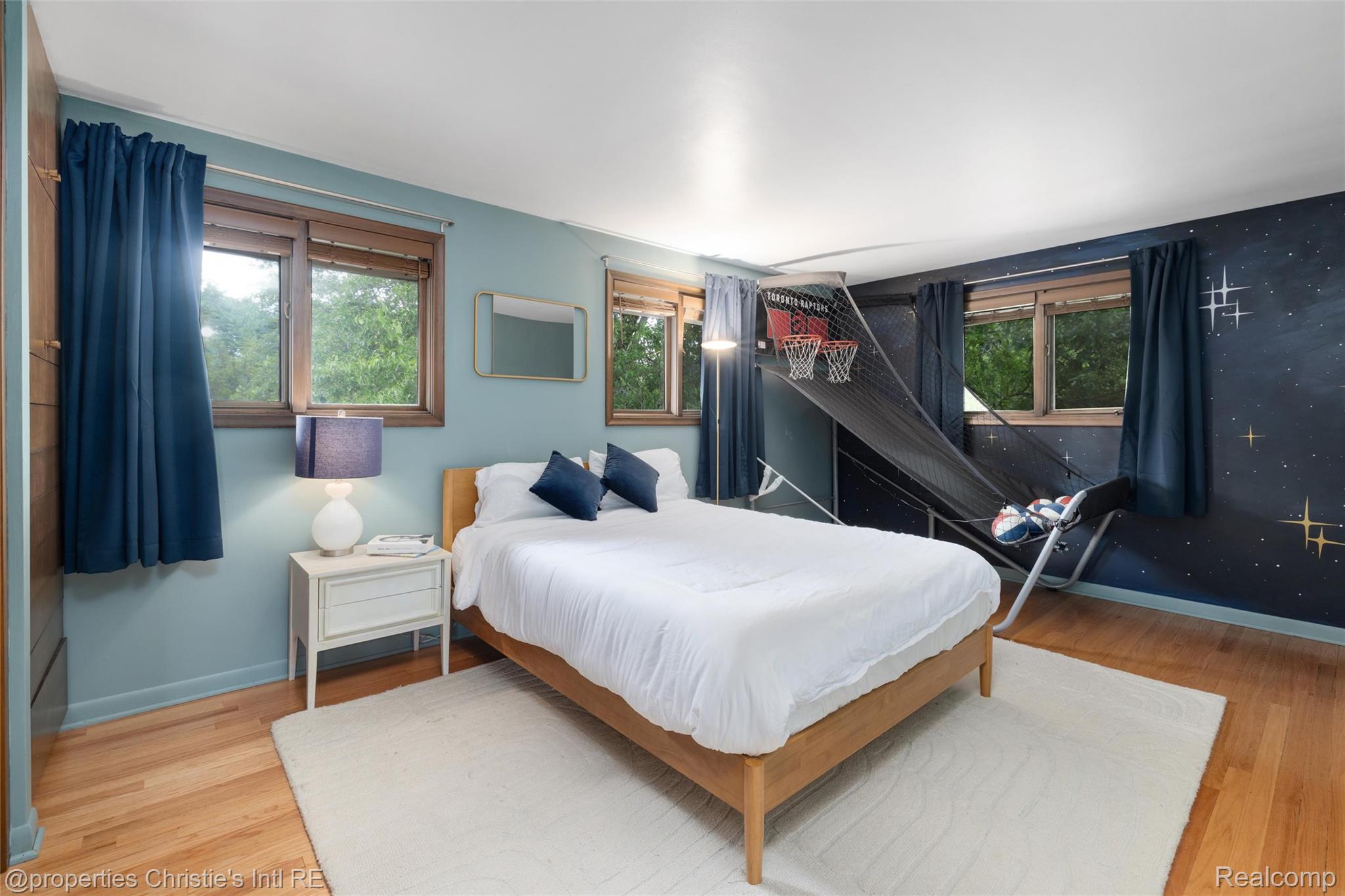 2771 West Seven Mile Road Detroit, MI 48221 - Photo 39 of 57 Hardwood-style flooring throughout this space features light blue painted walls and an accent wall with a celestial-themed mural