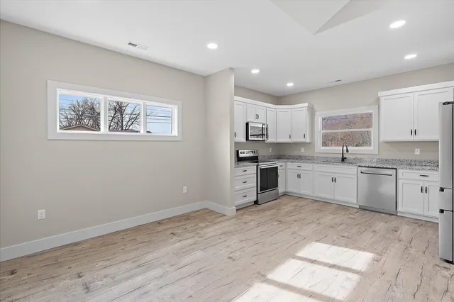 a kitchen with stainless steel appliances granite countertop a stove sink and cabinets