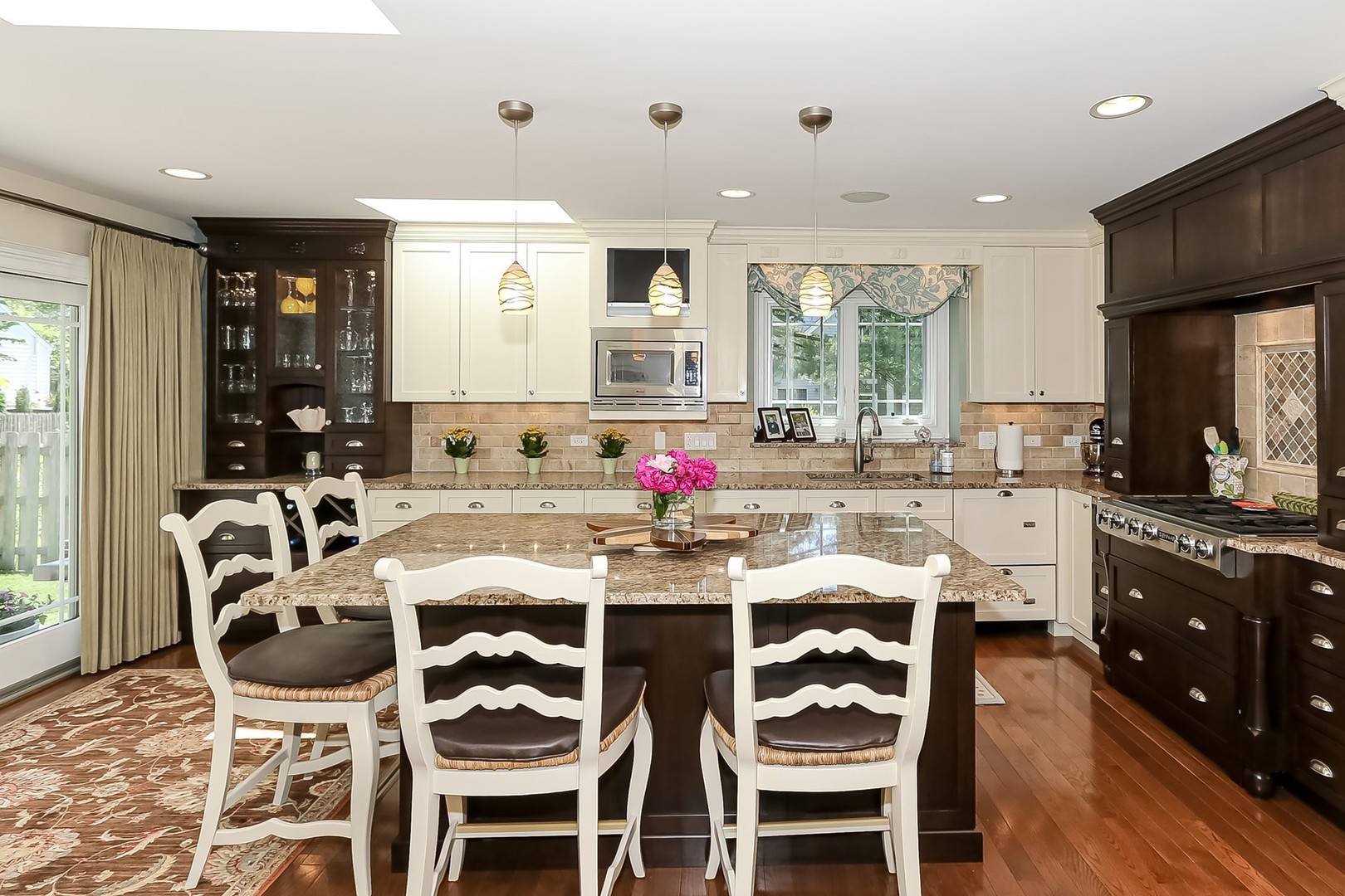 1117 Old Colony Road Lake Forest, IL 60045 - Photo 17 of 45 a kitchen with stainless steel appliances granite countertop a stove a sink dishwasher a dining table and chairs with wooden floor
