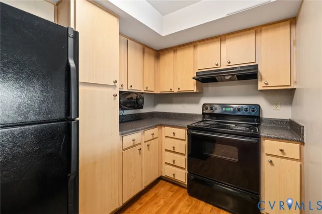 a kitchen with stainless steel appliances granite countertop a stove a refrigerator and cabinets