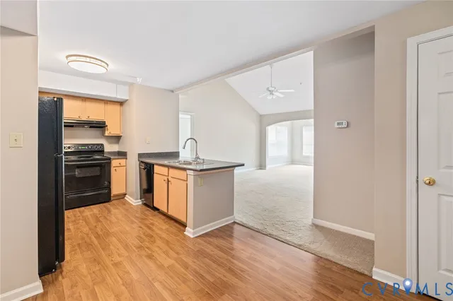 a kitchen with granite countertop a refrigerator and a stove top oven