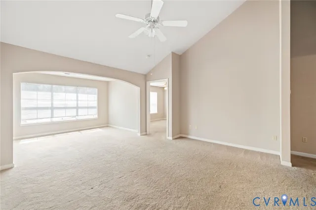 an empty room with windows and ceiling fan