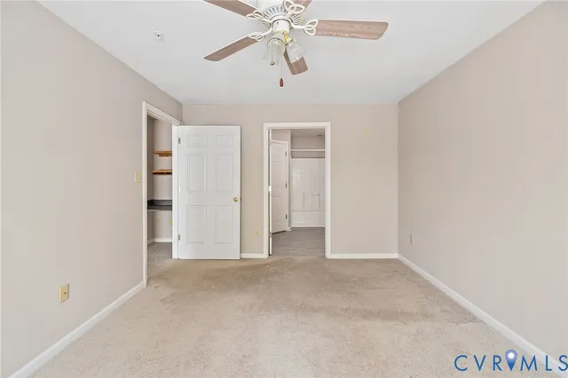 an empty room with a window and a ceiling fan