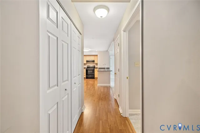 a view of a hallway with wooden floor and staircase