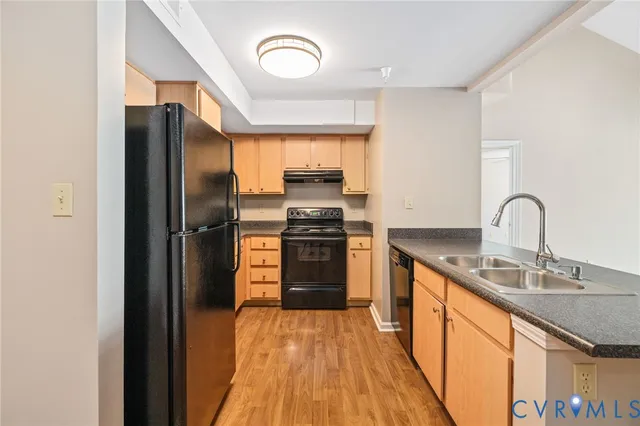 a kitchen with stainless steel appliances granite countertop a refrigerator and a sink