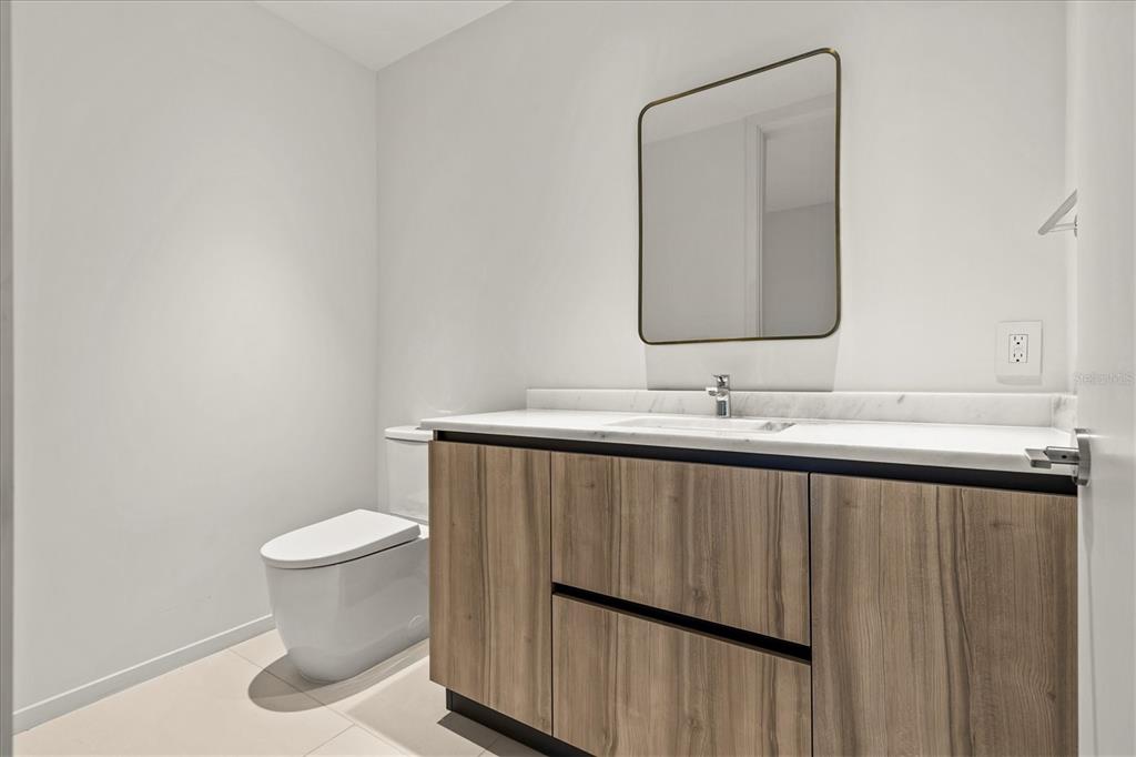 1020 Sunset Point Road, Unit 108 Clearwater, FL 33755 - Photo 23 of 62 a bathroom with a sink a toilet and mirror