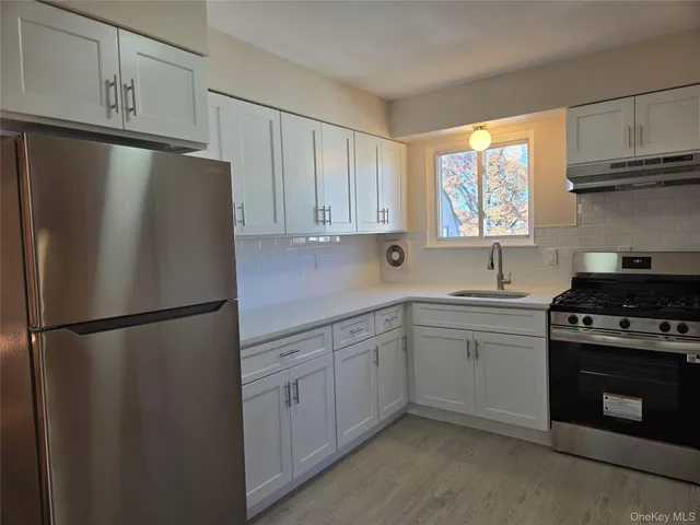 a kitchen with a refrigerator sink and cabinets