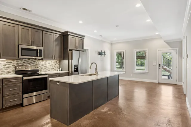 a kitchen with stainless steel appliances granite countertop a sink stove and refrigerator