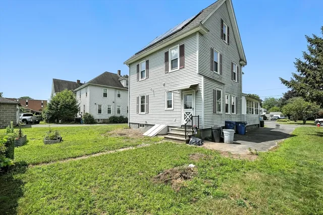 a view of a house with a yard and sitting area