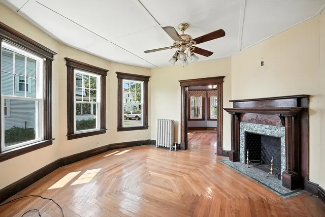 a view of an empty room with window and fire place