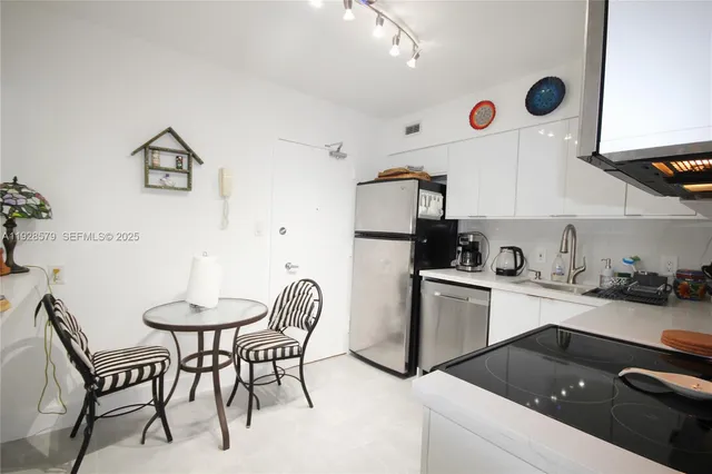 a kitchen with a table chairs and a refrigerator
