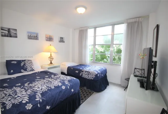 a bedroom with two beds and a window