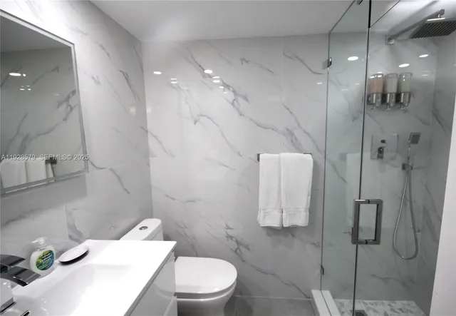 a bathroom with a sink toilet and shower